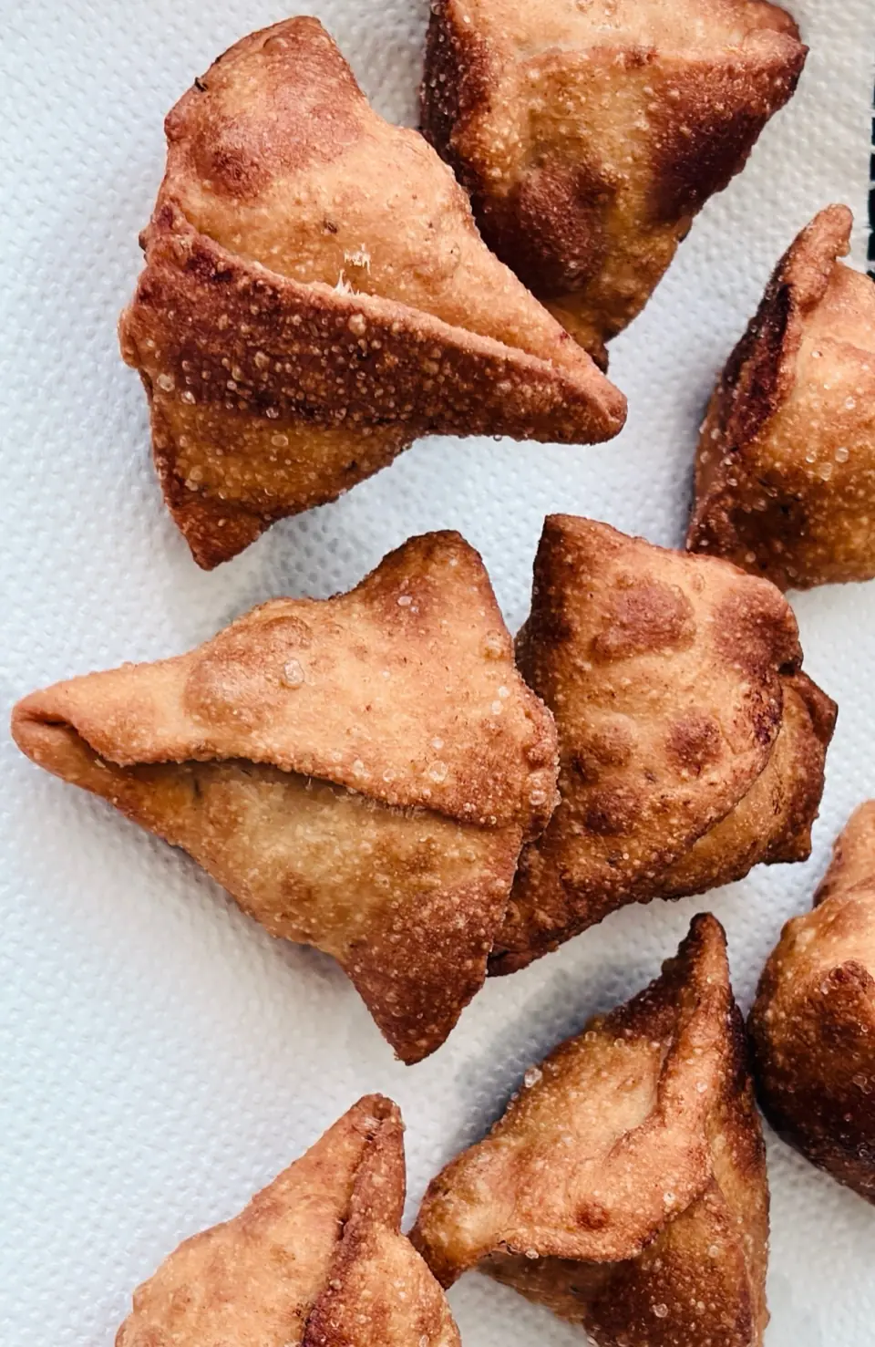 Golden samosas on white paper