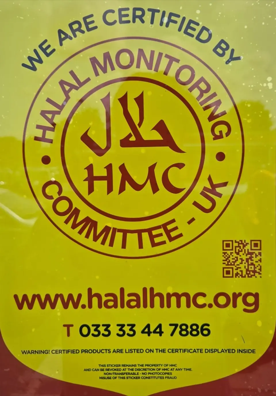 The yellow 'We are certified by Halal Monitoring Committee' sticker in the shop window